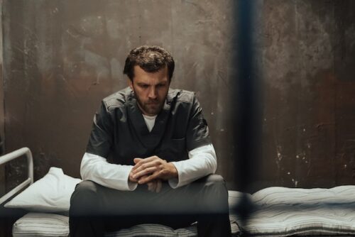 man sitting in jail alone