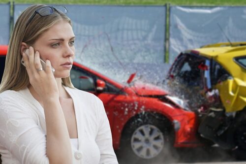 woman on phone in front of accident scene