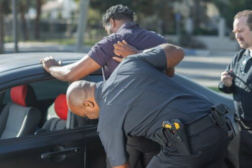 man being searched outside of vehicle