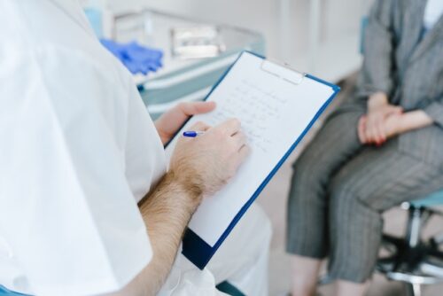 person meeting with a doctor holding clipboard
