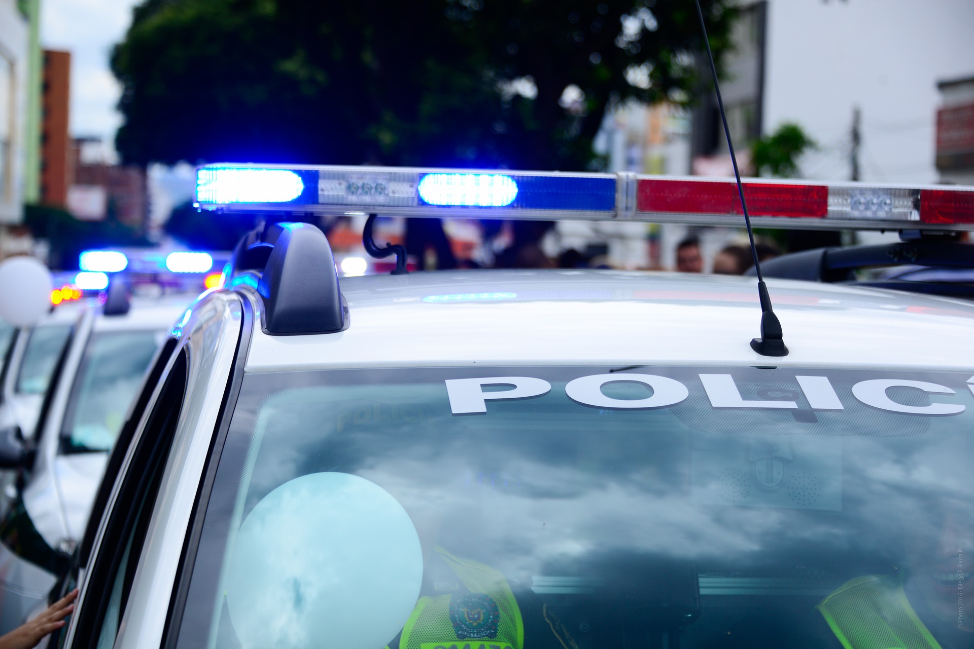 police lights on police cruiser outside a residential home; Sacramento Domestic Violence Defense Lawyer concept image