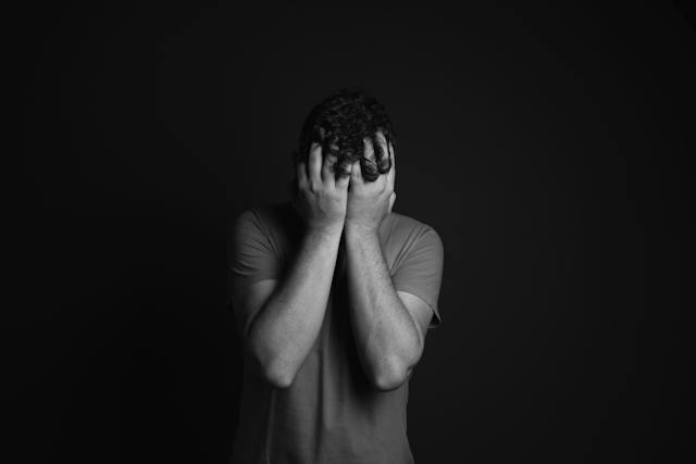 man with face in hands