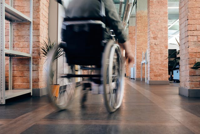 person in wheelchair moving down hallway