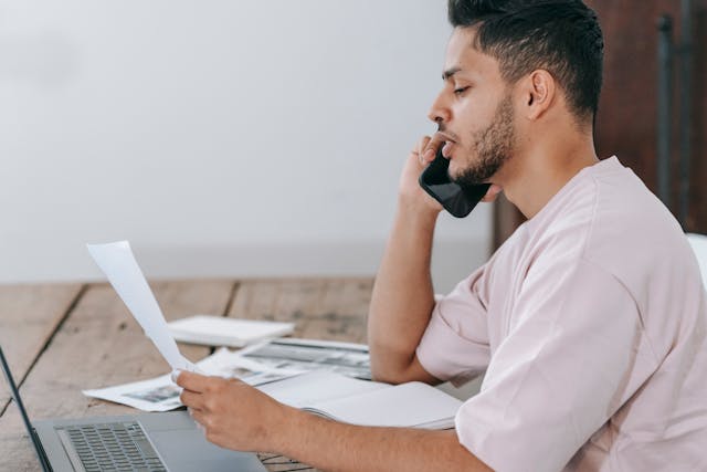 man on phone looking at paper