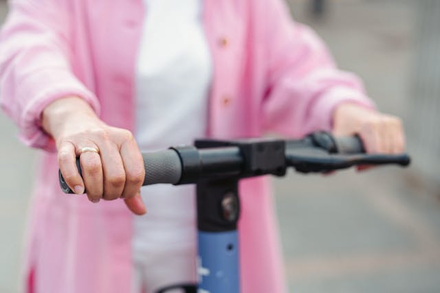 person holding electric scooter handle bars