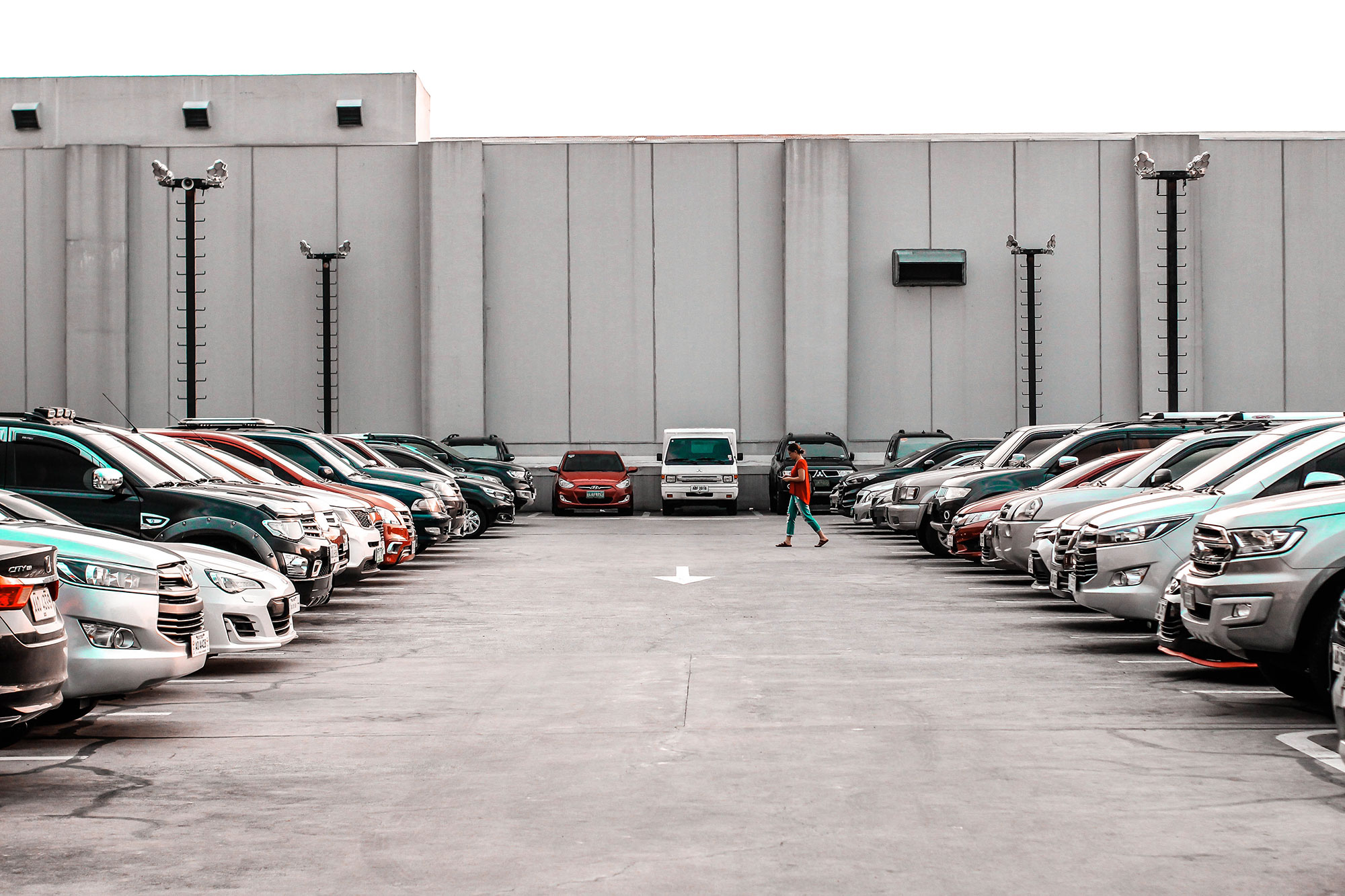 A fully occupied parking lot outside a large cement building; Sacramento Parking Lot Accident Lawyer concept image