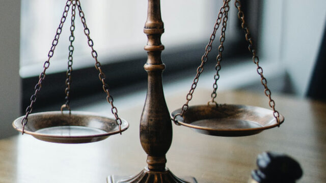 A legal justic scale on desk - Criminal Defense Lawyer concept image
