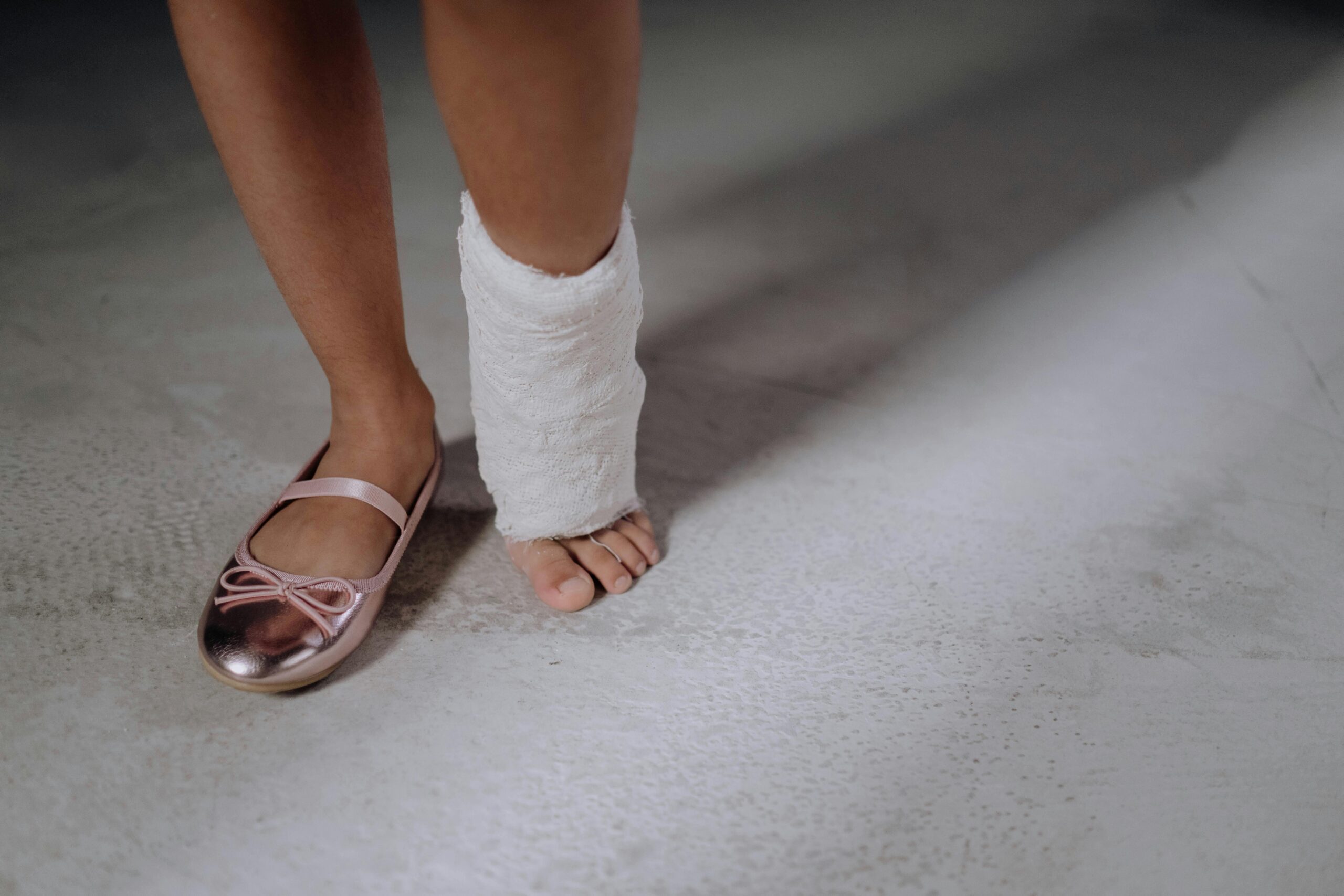 A woman's legs, one foot in a slipper the other in a cast, limping; Placerville Personal Injury Criminal Lawyers concept image